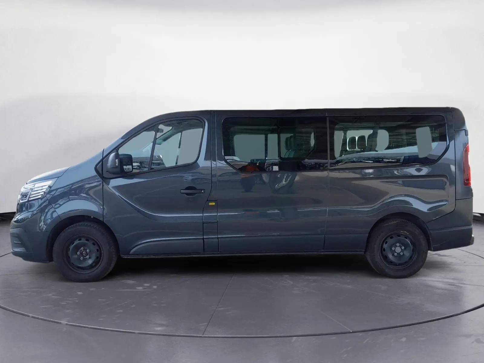 Renault Trafic Combi gris foncé métal vu de profil côté gauche, grand fourgon 9 places avec vitres teintées.