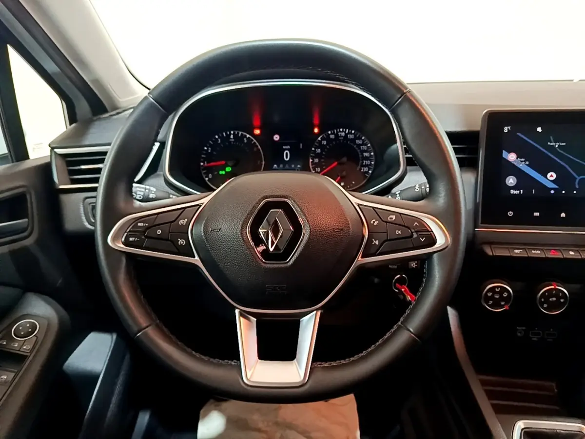 Vue rapprochée du volant en cuir noir d'une Renault Clio Business TCe 100 avec tableau de bord et écran tactile.