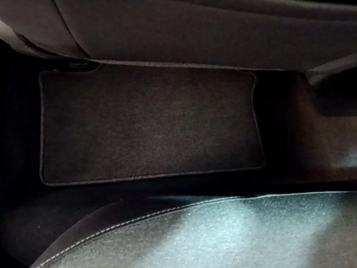 Tapis de sol noir côté passager arrière d'une Renault Clio Business TCe 100 blanche de 2019.