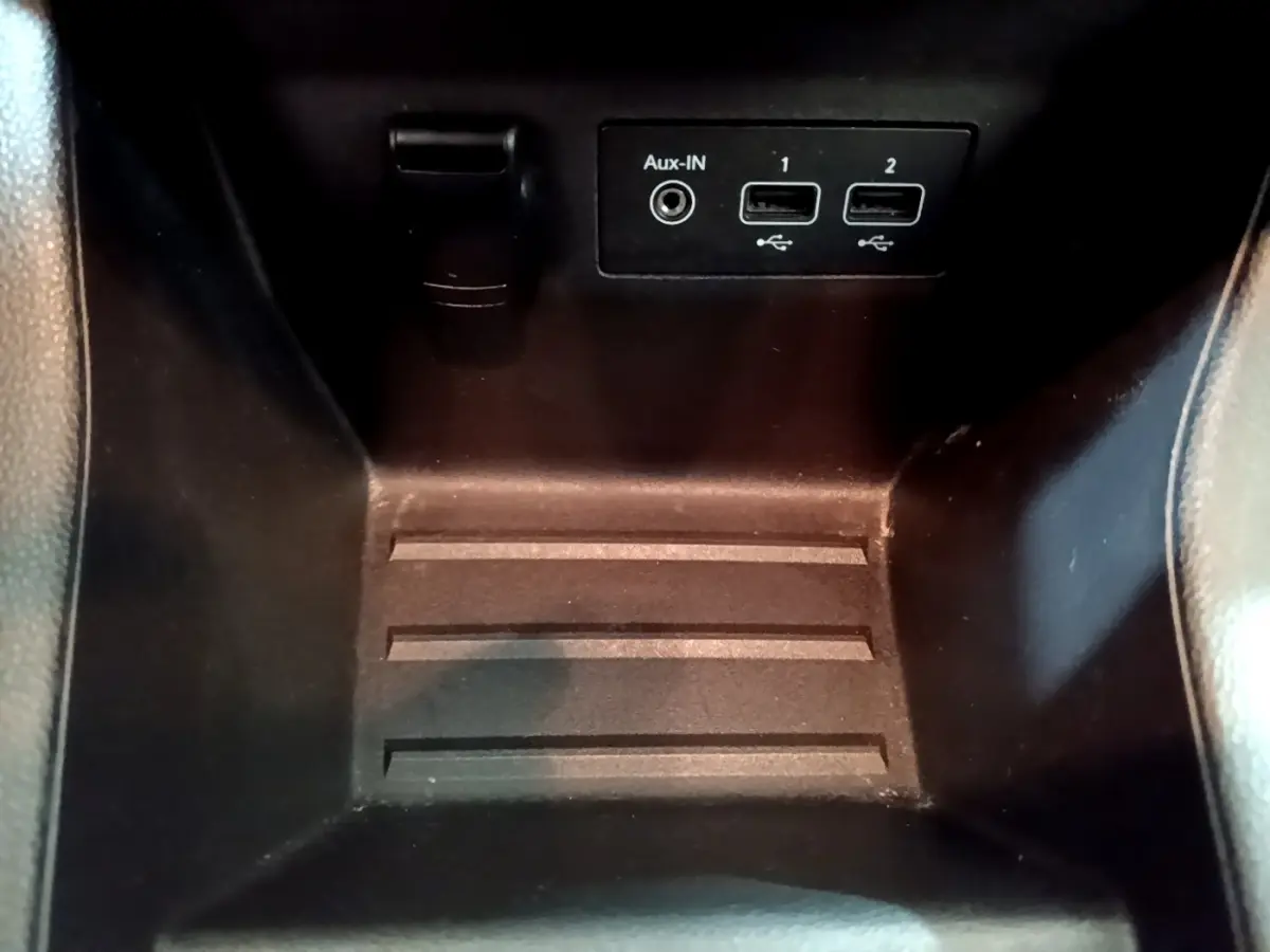 Gros plan sur la console centrale noire de la Renault Clio Business TCe 100 avec ports USB et entrée Aux-In visibles.