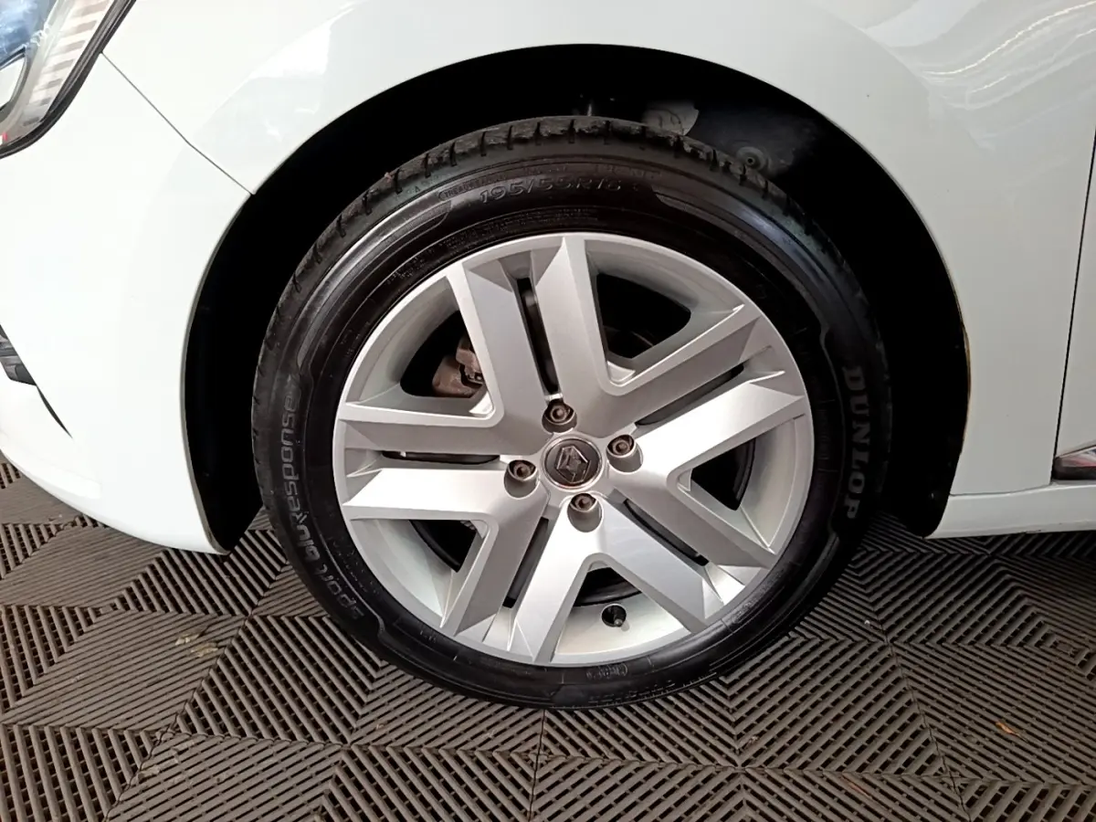 Gros plan sur la roue avant gauche blanche d'une Renault Clio Business TCe 100 de 2019 avec jante alliage argentée.