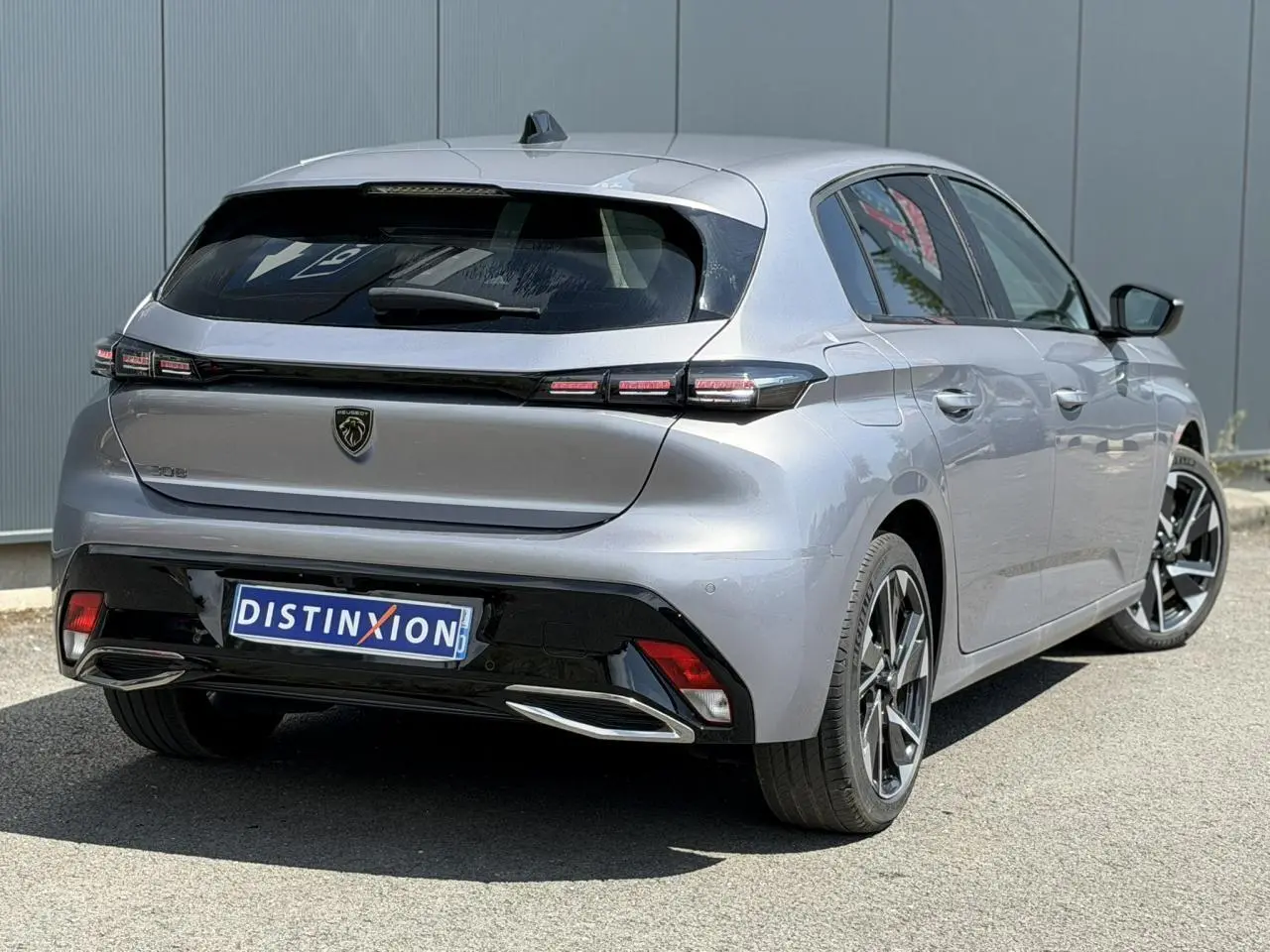 Vue 3/4 arrière droite de la Peugeot 308 Hybrid 145 gris Artense, avec feux arrière LED et jantes alliage 17 pouces.
