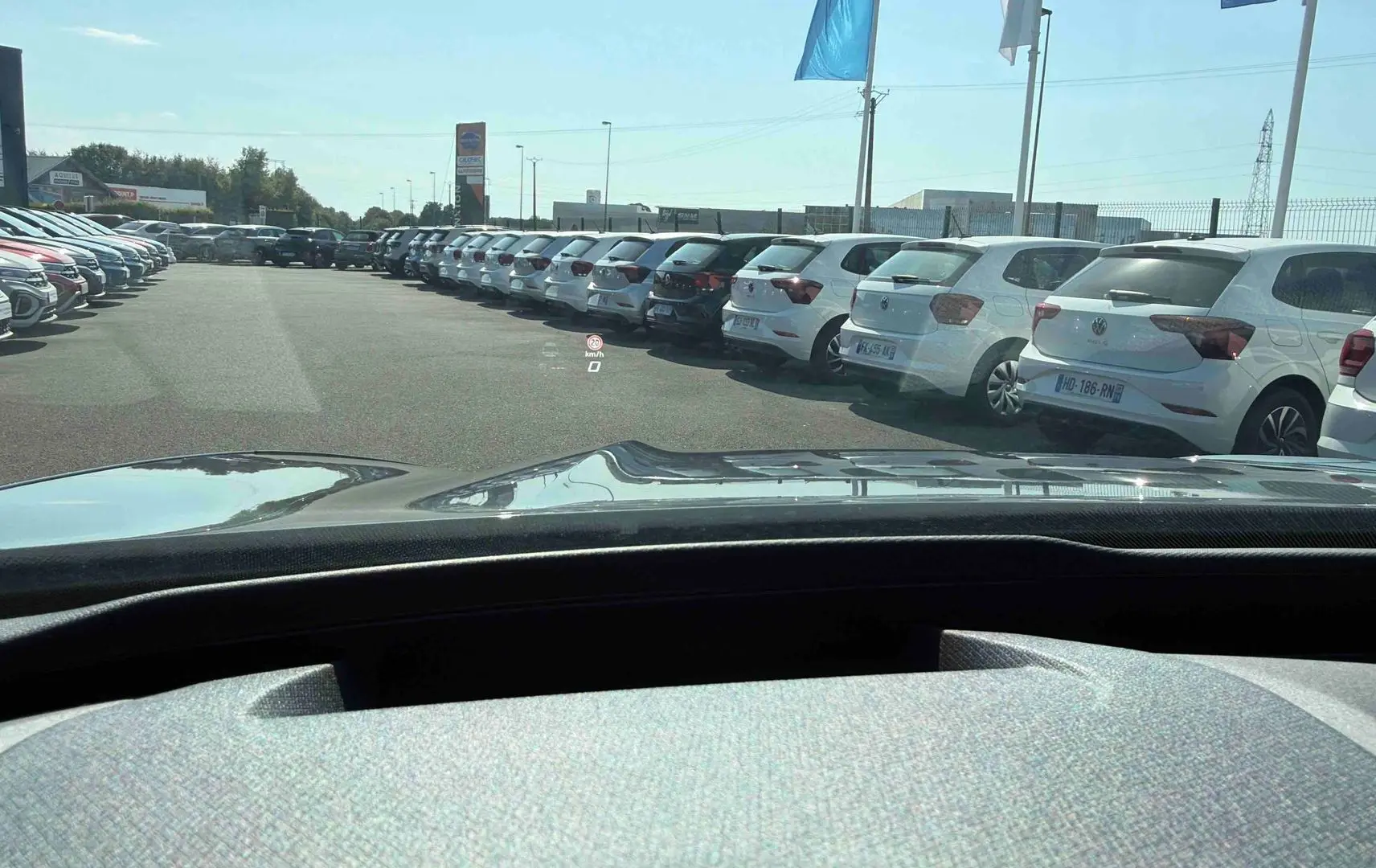 Vue depuis l'habitacle d'une CUPRA TERRAMAR grise, avec affichage tête haute visible sur le pare-brise en extérieur.