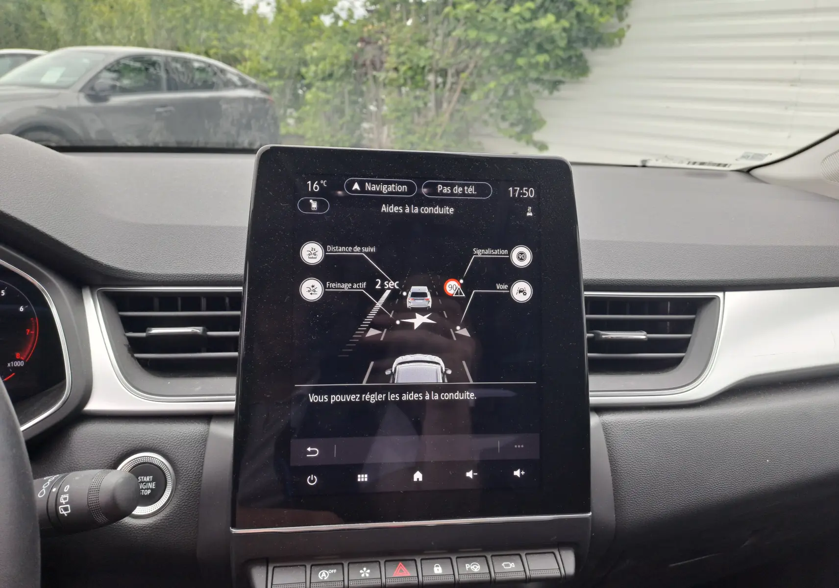 Vue intérieure du tableau de bord du Renault Captur 2024, écran tactile central affichant les aides à la conduite.