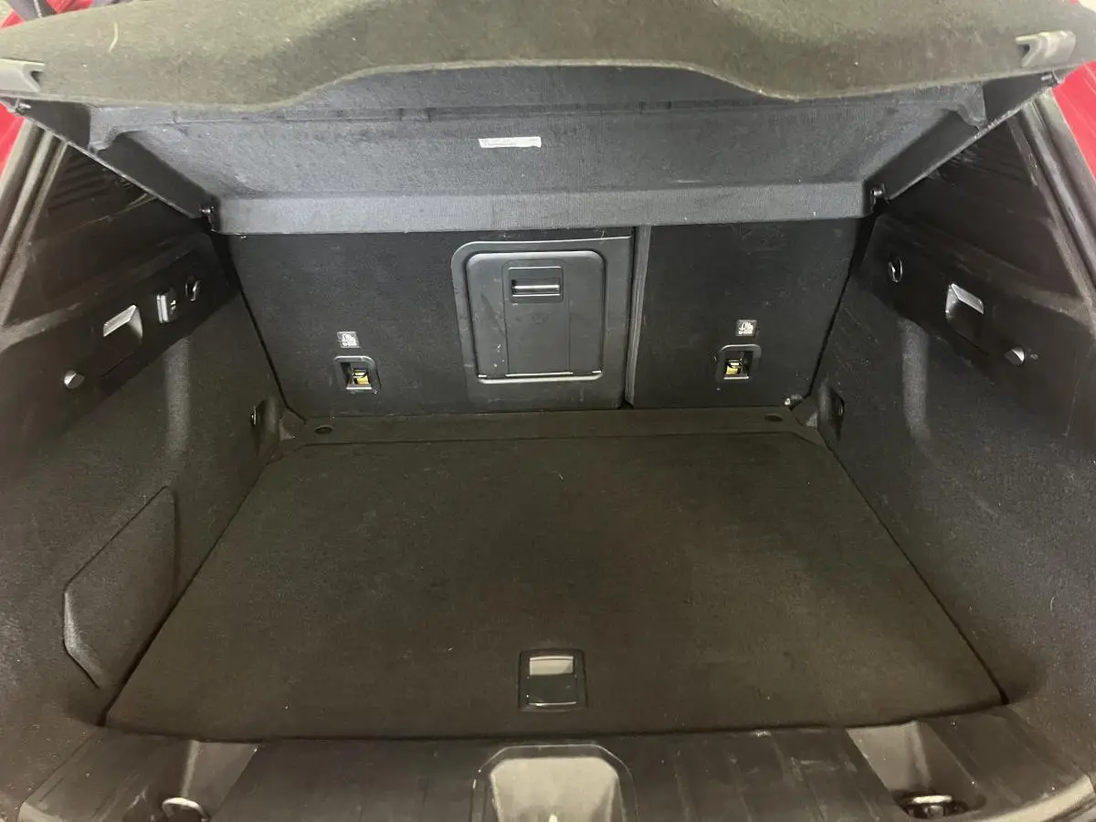 Coffre ouvert de l'Alfa Romeo Tonale rouge 2024, montrant l'espace de chargement intérieur noir.