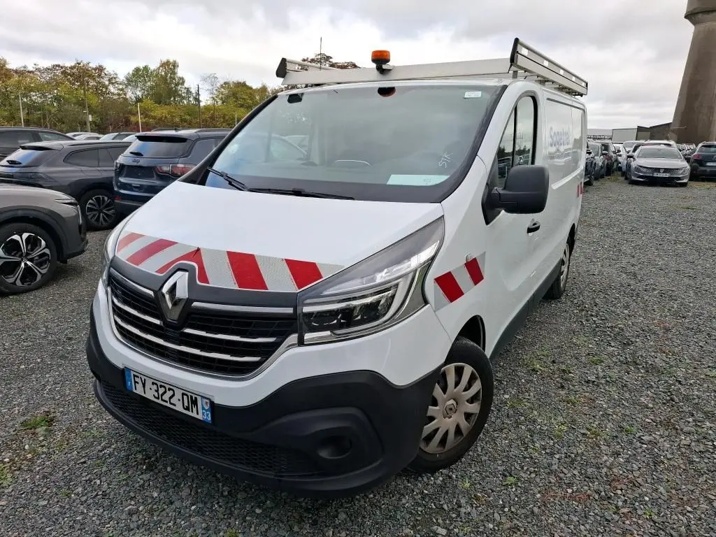 Renault Trafic Fourgon blanc en 3/4 avant droit avec bandes rouges réfléchissantes et galerie sur le toit.
