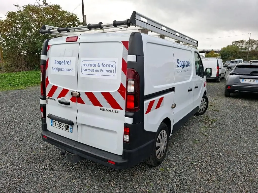 Renault Trafic Fourgon blanc vu en 3/4 arrière droit avec marquages rouges et logo Sogetrel sur les portes arrière et latérales.