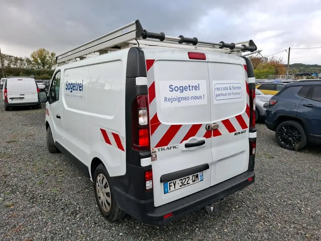Vue 3/4 arrière droite du Renault Trafic blanc avec marquage Sogetrel et galerie sur le toit.