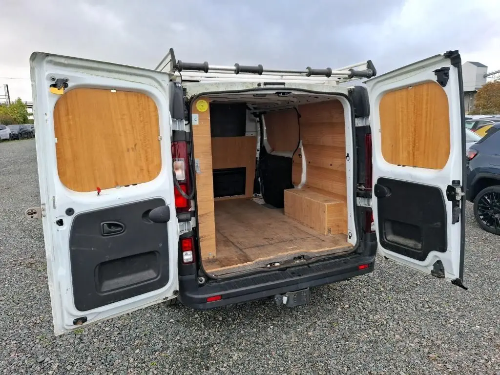 Vue arrière ouverte du Renault Trafic Fourgon blanc 2021 avec aménagement intérieur en bois visible.