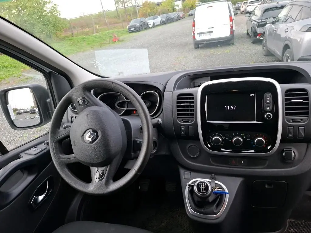 Vue intérieure du poste de conduite du Renault Trafic Fourgon blanc 2021, volant multifonction et écran central tactile.