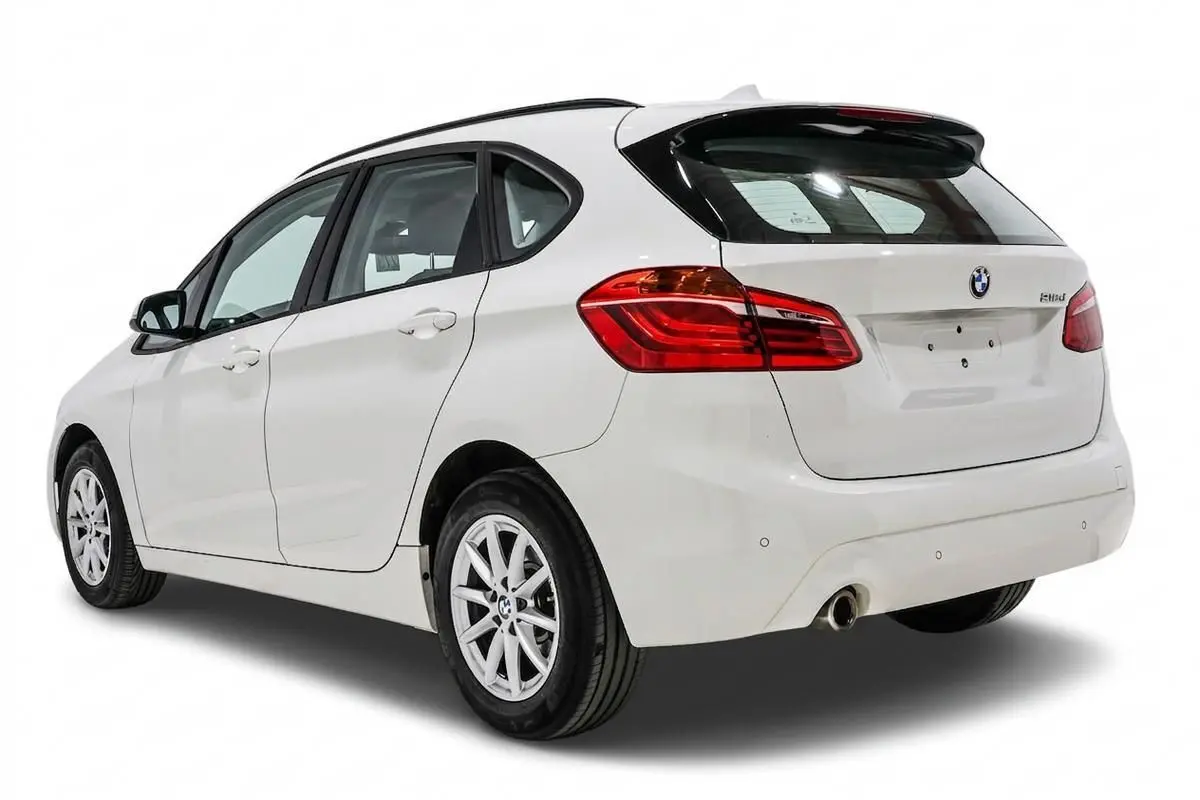 Vue 3/4 arrière droite d'une BMW Série 2 Active Tourer 216d blanche avec feux LED et jantes alliage.
