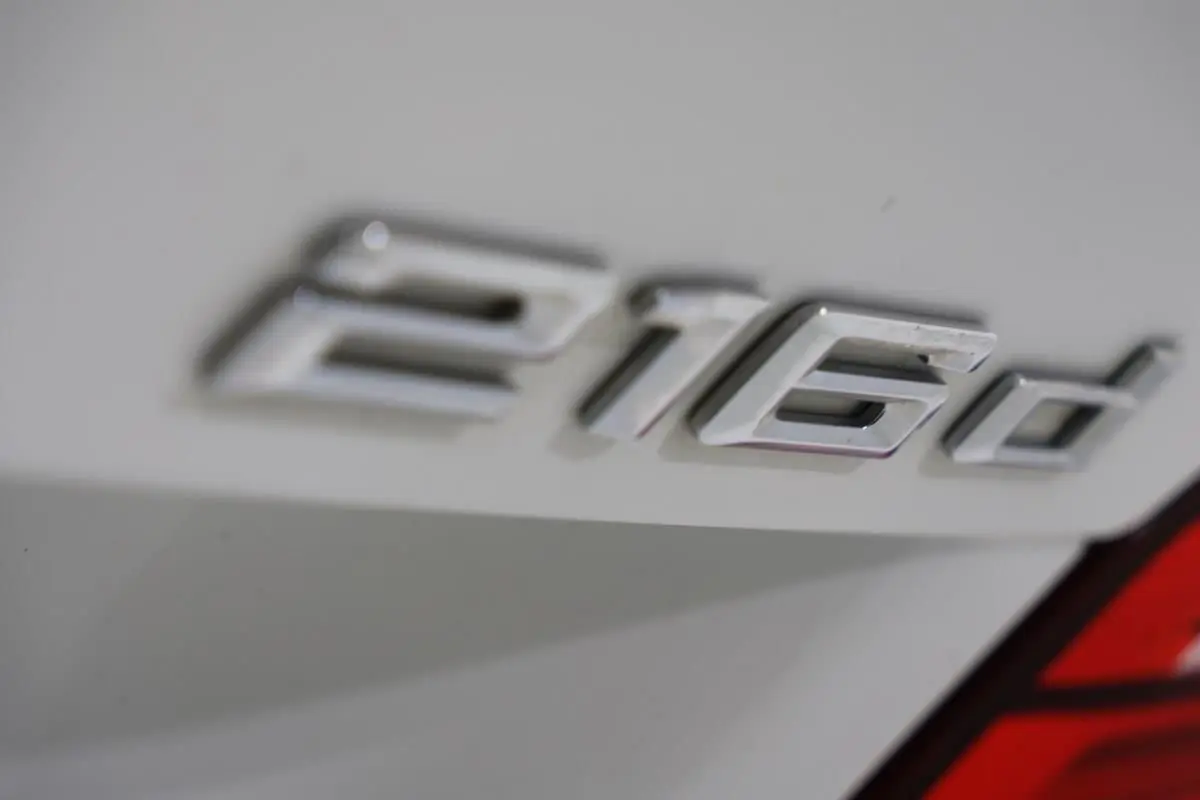 Gros plan sur l’inscription 216d en chrome sur la partie arrière blanche d’une BMW Série 2 Active Tourer.
