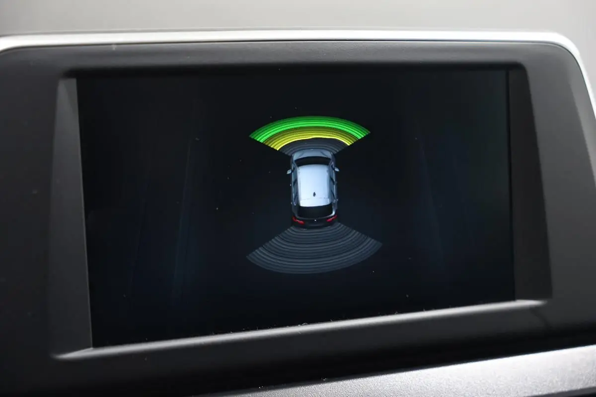 Écran de la BMW Série 2 Active Tourer 216d montrant le système de radars de stationnement avec alertes visuelles.