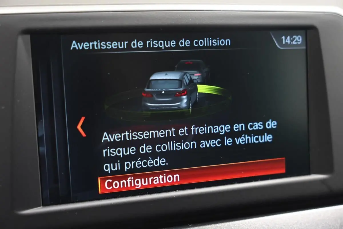 Écran de bord affichant l'avertisseur de risque de collision avec illustration de deux véhicules gris.