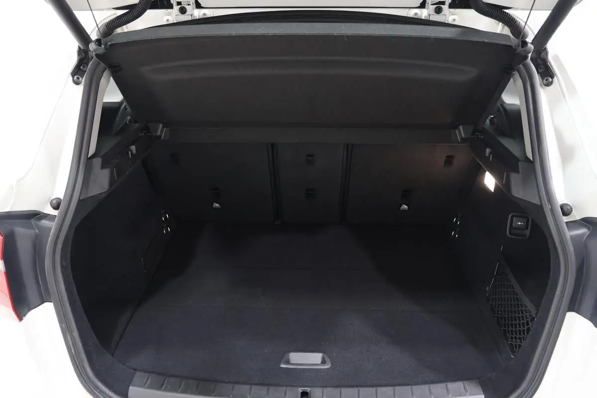Coffre arrière ouvert d'une BMW Série 2 Active Tourer blanche, vue de face montrant l'espace de chargement vide et propre.