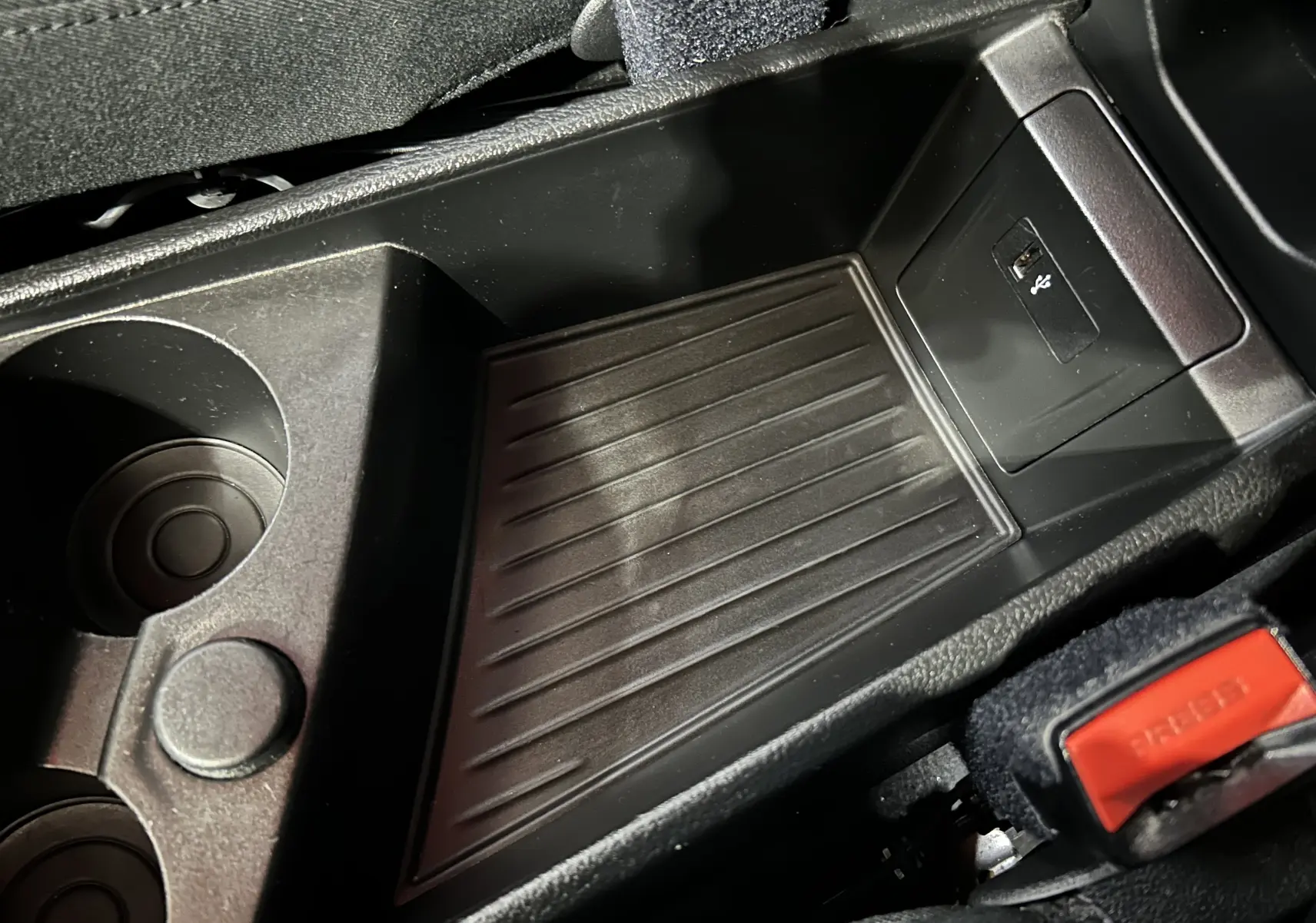 Détail de la console centrale noire avec porte-gobelets et port USB de la BMW Série 2 Active Tourer blanche.