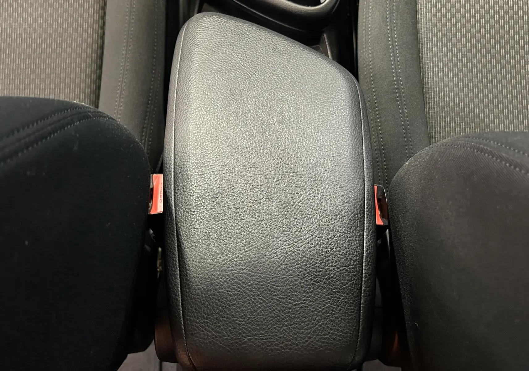 Gros plan sur l'accoudoir central en cuir noir entre les sièges avant d'une BMW Série 2 Active Tourer 216d.