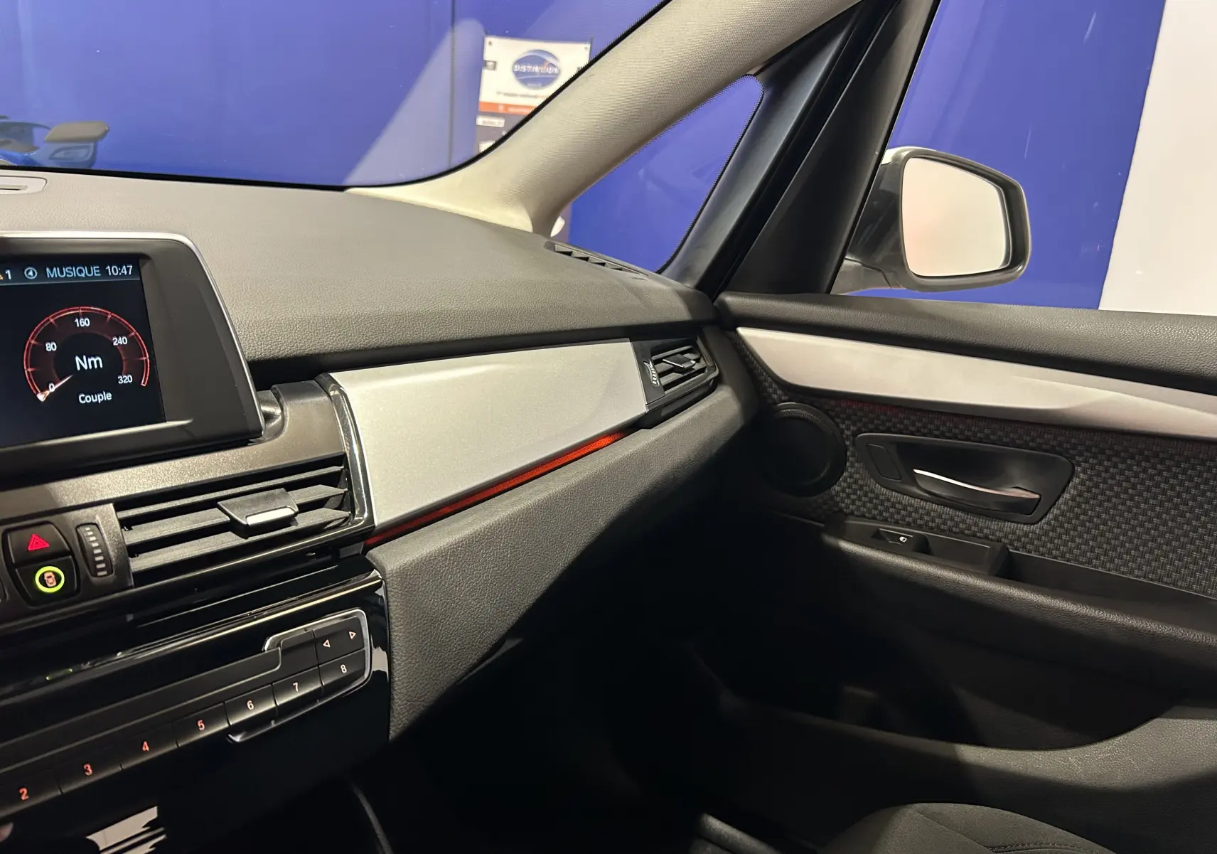 Vue intérieure côté passager de la BMW Série 2 Active Tourer 216d 2021 avec tableau de bord noir et détails argentés.