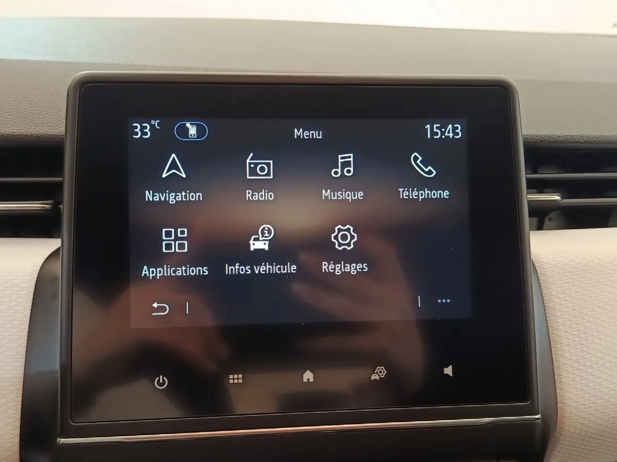 Écran tactile central de la Renault Clio 2023 affichant le menu principal avec navigation et radio.