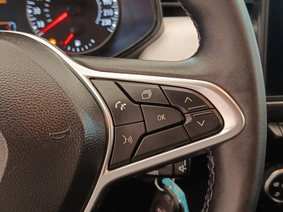 Gros plan sur le volant cuir noir de la Renault Clio 2023, avec commandes multifonctions visibles côté droit.