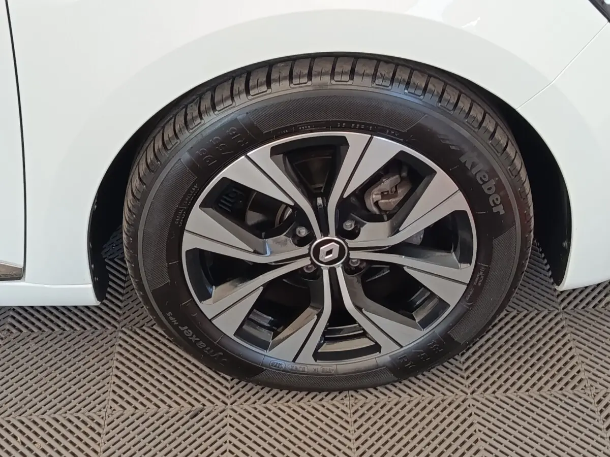 Gros plan sur la roue avant droite de la Renault Clio blanche, mettant en valeur la jante alliage au design moderne.