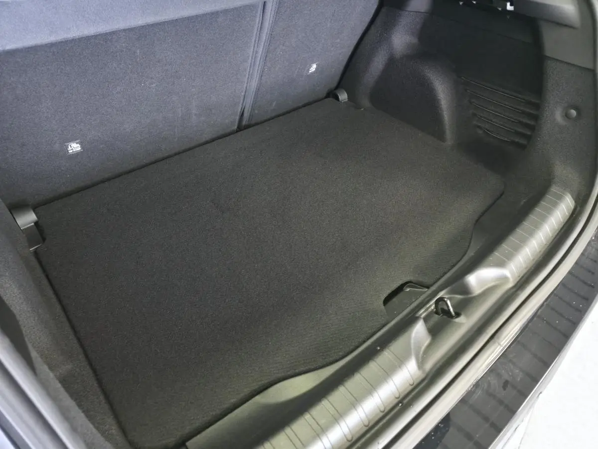 Vue rapprochée du coffre noir du Fiat 600 1.2 Hybrid Icône 2025, montrant le plancher et les finitions intérieures.