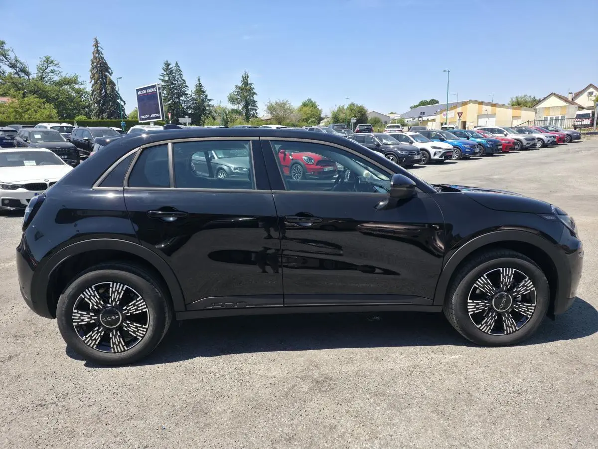 Vue de profil côté gauche d'une FIAT 600 noire 2025 avec jantes alliage et coques de rétroviseurs noires brillantes.