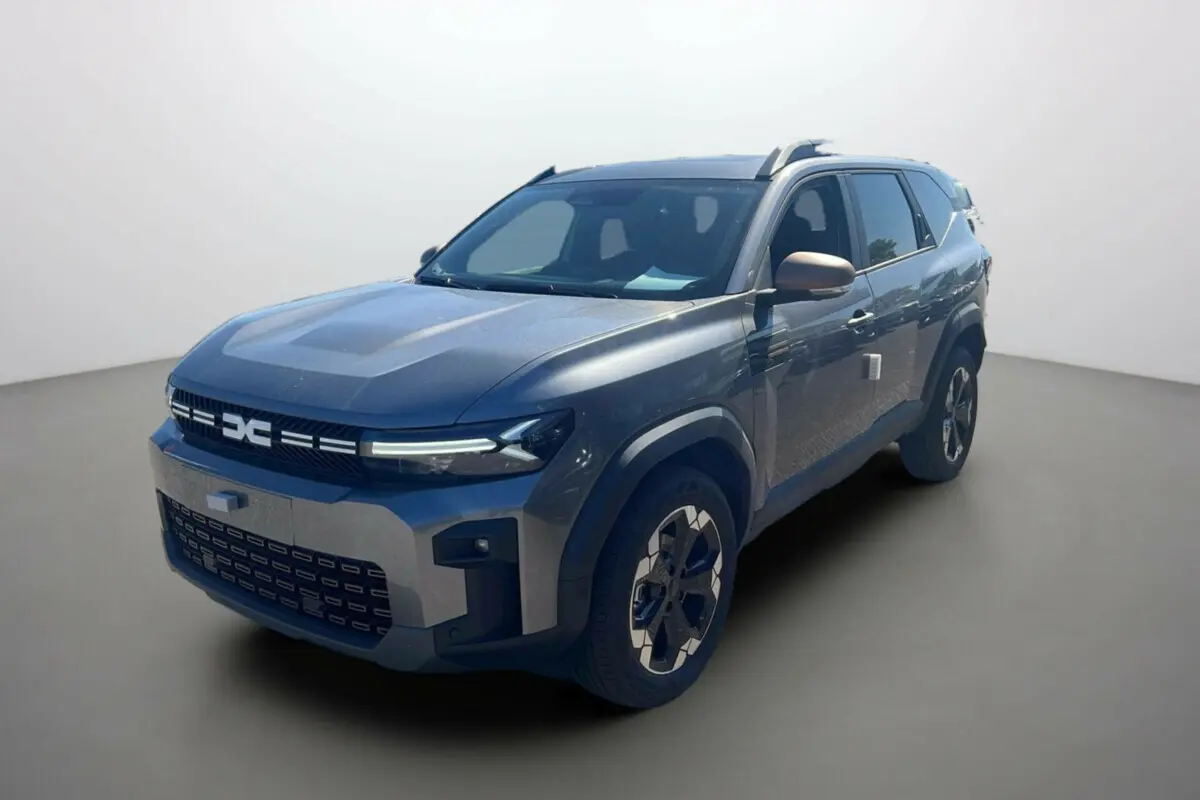 SUV Dacia Bigster TCE 130 4x4 Extreme Plus gris schiste vu en 3/4 avant droit avec calandre moderne et jantes spécifiques.