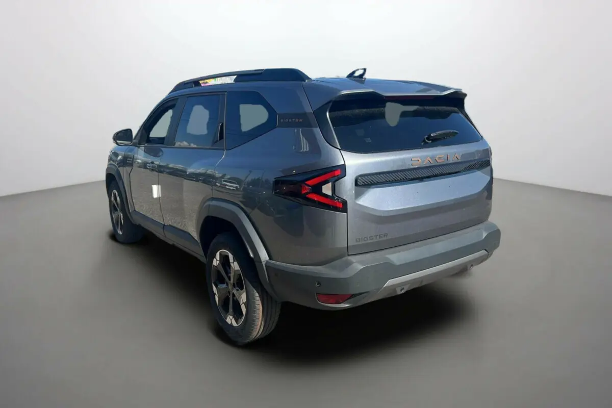 Vue 3/4 arrière droite du Dacia Bigster gris schiste 2025 avec logo et feux arrière en forme de flèche.