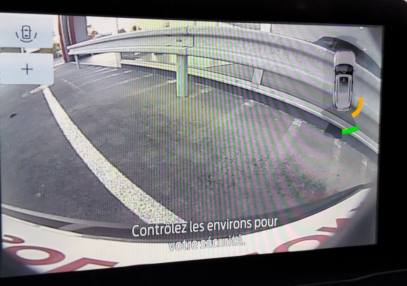 Vue caméra de recul du Ford Puma gris Fashion Metallic montrant un parking avec barrières de sécurité.