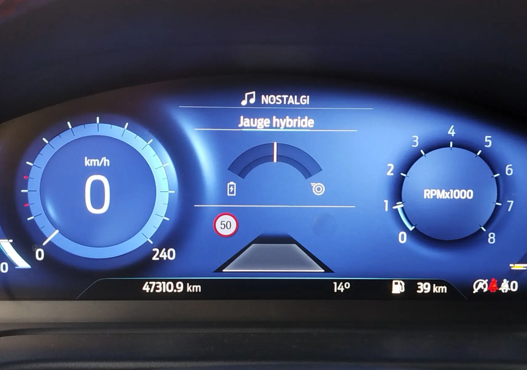 Tableau de bord numérique du Ford Puma 1.0 EcoBoost hybride, affichant vitesse à zéro et jauge hybride au centre.