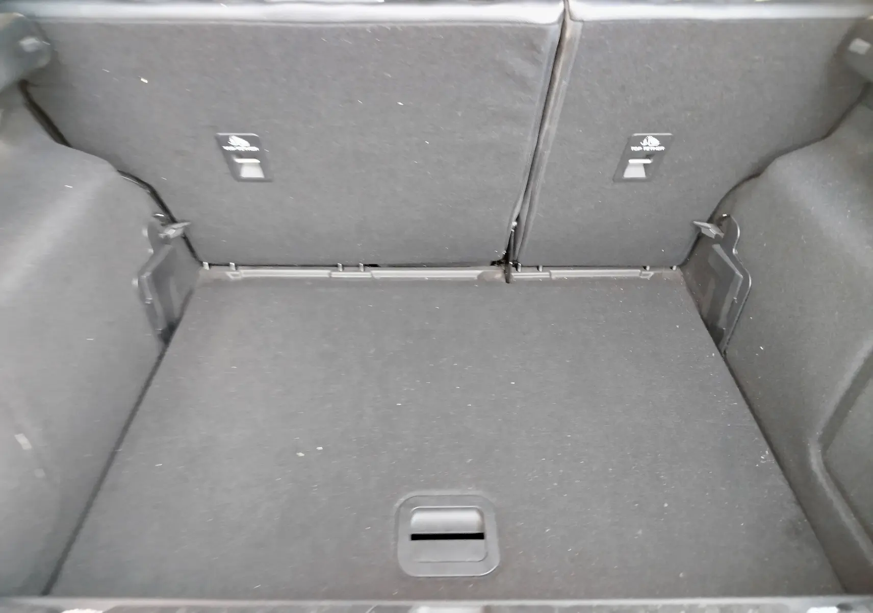 Coffre spacieux vu de l'intérieur arrière du Ford Puma 1.0 EcoBoost gris, avec banquette arrière rabattue.