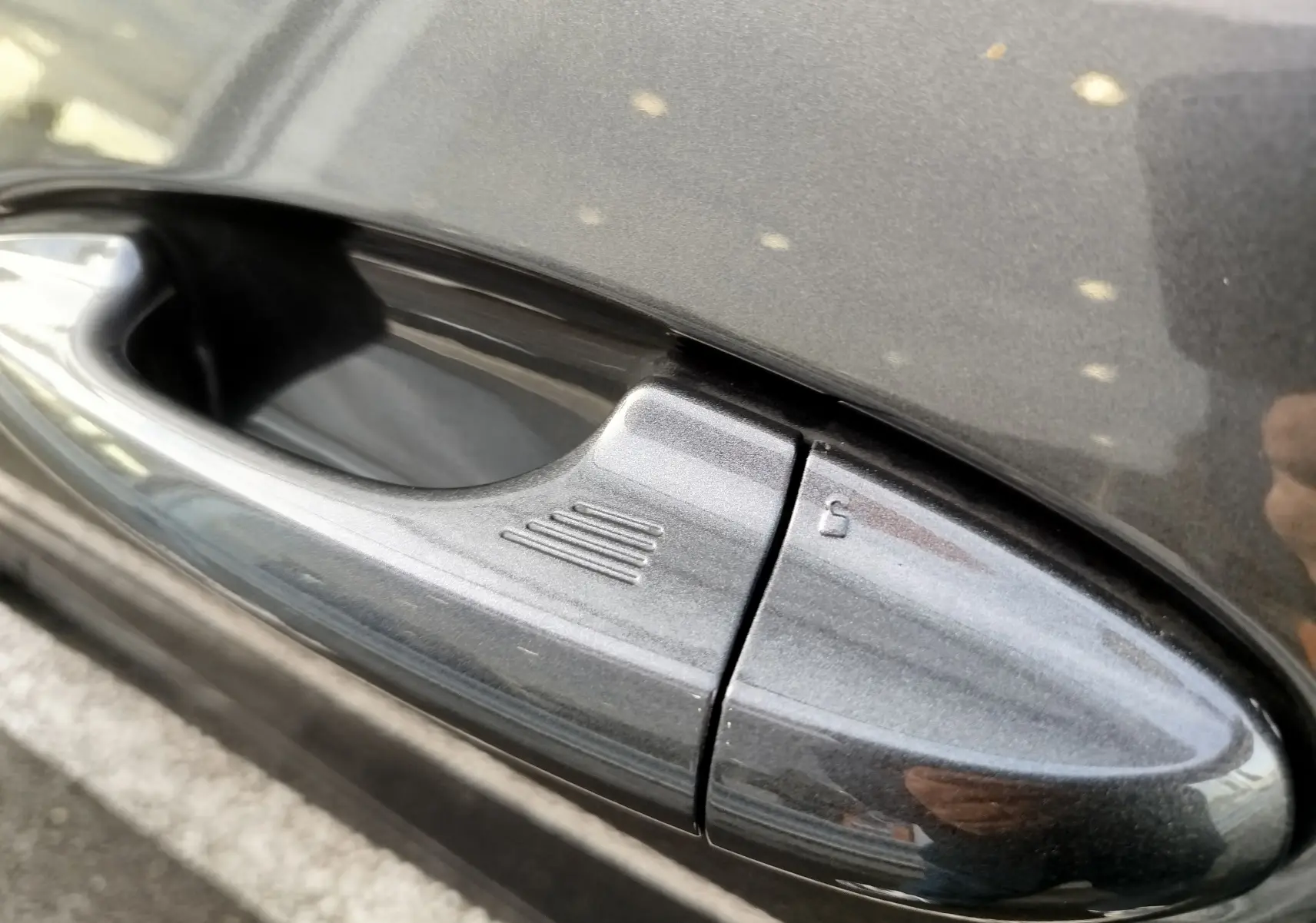 Poignée de porte côté gauche gris métallisé du Ford Puma 1.0 EcoBoost 125ch mHEV ST-Line X 2020 avec bouton de déverrouillage intégré.