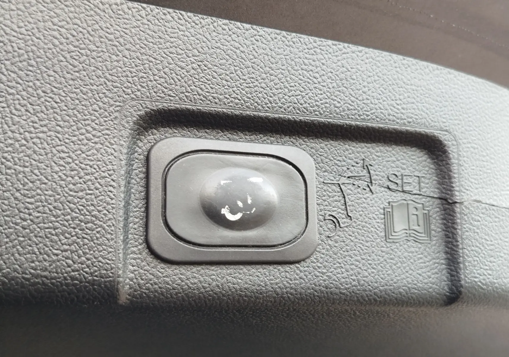 Bouton de réglage du hayon électrique sur plastique noir texturé à l'intérieur du Ford Puma gris métallisé 2020.