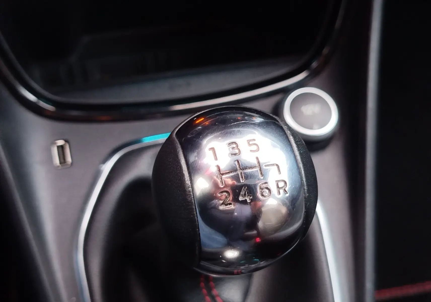 Le levier de vitesses manuel chromé en gros plan dans l'habitacle sombre d'une Ford Puma 2020.