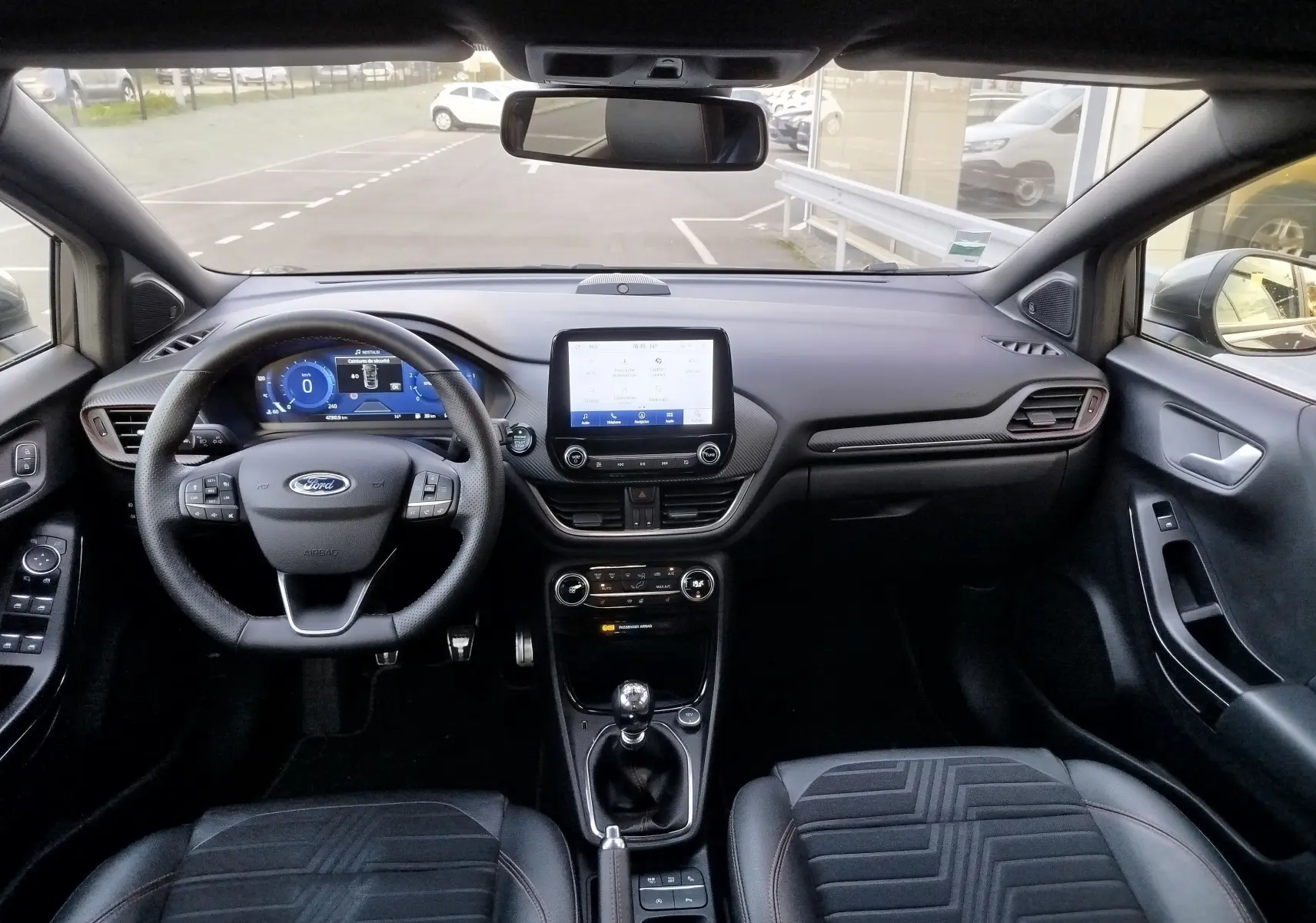 Intérieur du Ford Puma 1.0 EcoBoost 2020, vue frontale du tableau de bord avec écran tactile et volant multifonction noir.