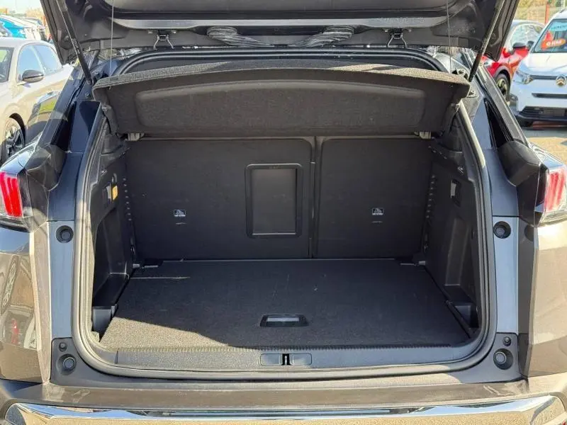 Coffre ouvert vu de l'arrière d'un Peugeot 3008 Gris Platinium 2024, montrant l'espace de chargement vide.