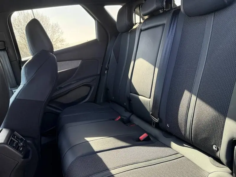 Vue intérieure côté droit des sièges arrière noirs du Peugeot 3008 2024, soulignant les finitions et ceintures de sécurité.