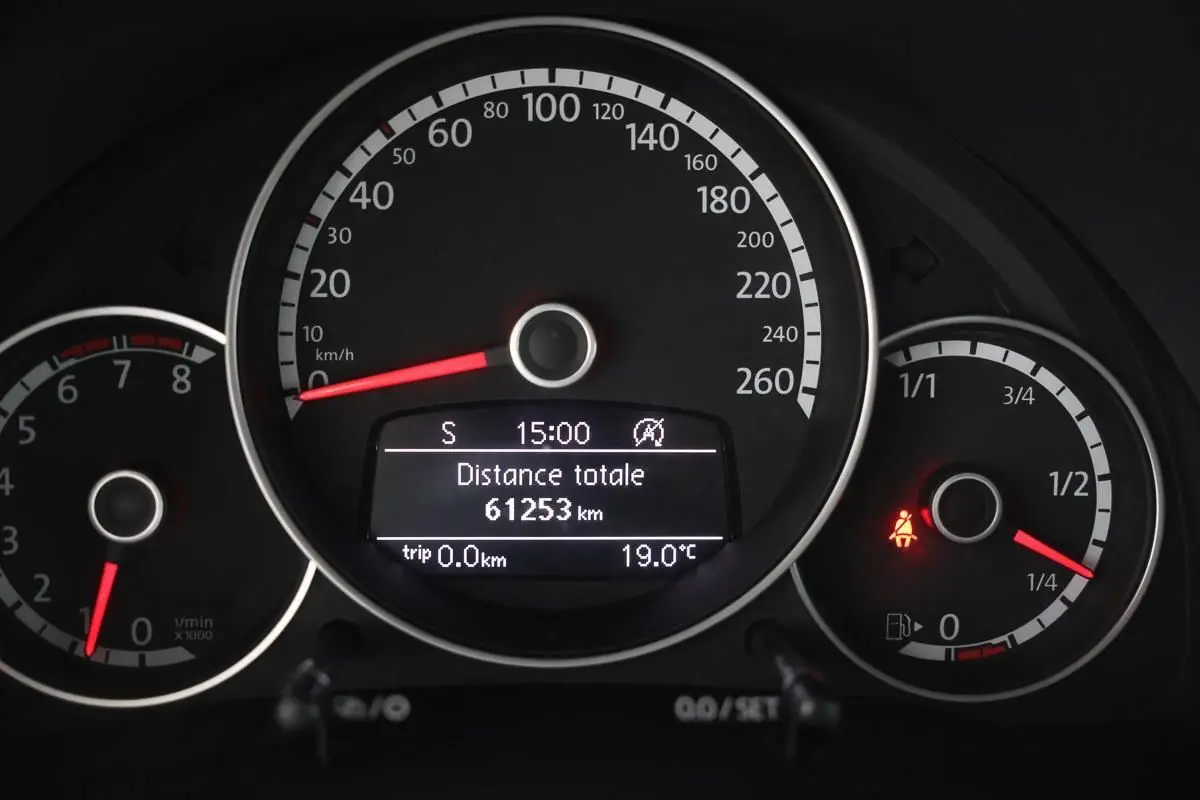 Vue rapprochée du tableau de bord de la Volkswagen Coccinelle 2016, affichant le compteur de vitesse et le kilométrage.