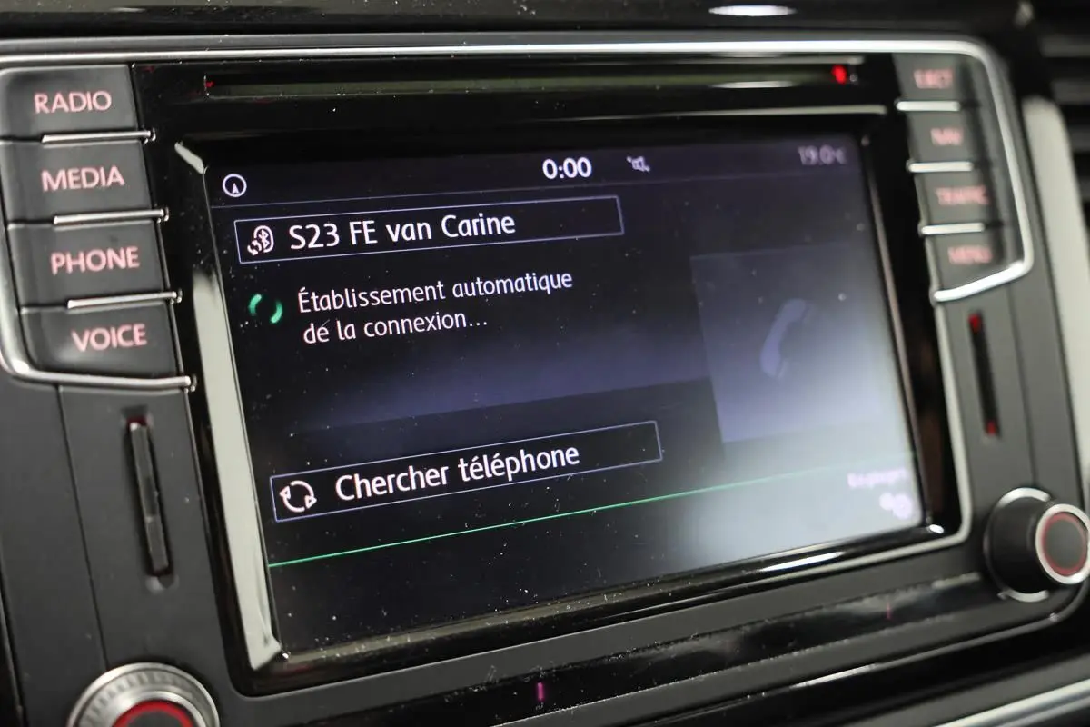Écran tactile du système GPS et multimédia de la Volkswagen Coccinelle 2016 avec commandes latérales visibles.