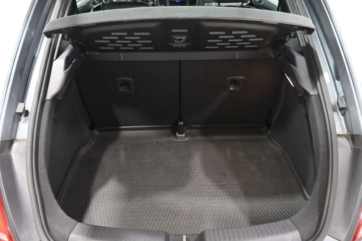 Coffre ouvert vu de l'arrière d'une Volkswagen Coccinelle gris 2016, montrant l'espace de chargement vide.