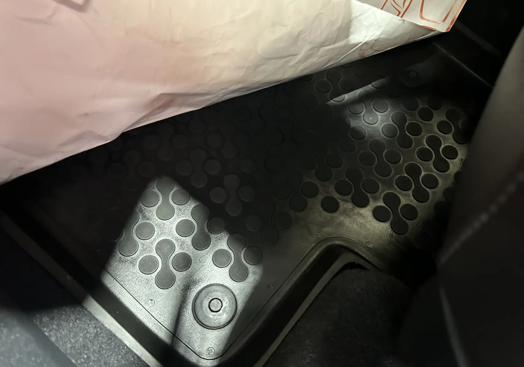 Détail du tapis de sol noir en caoutchouc avec motifs circulaires dans une Volkswagen Coccinelle gris 2016.