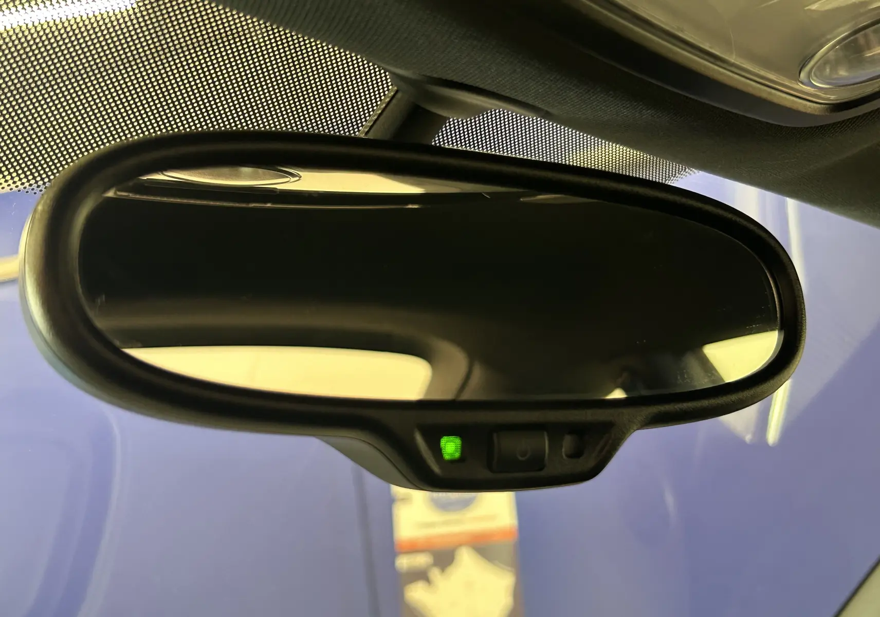 Rétroviseur intérieur noir de Volkswagen Coccinelle 2016 avec témoin vert d'activation, vue rapprochée depuis l'habitacle.
