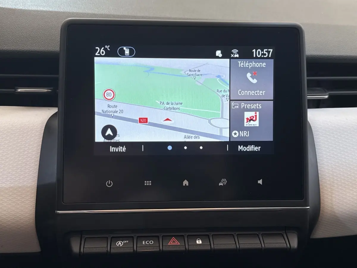 Écran tactile central affichant la navigation et les options multimédias dans le tableau de bord d'une Renault Clio blanche.