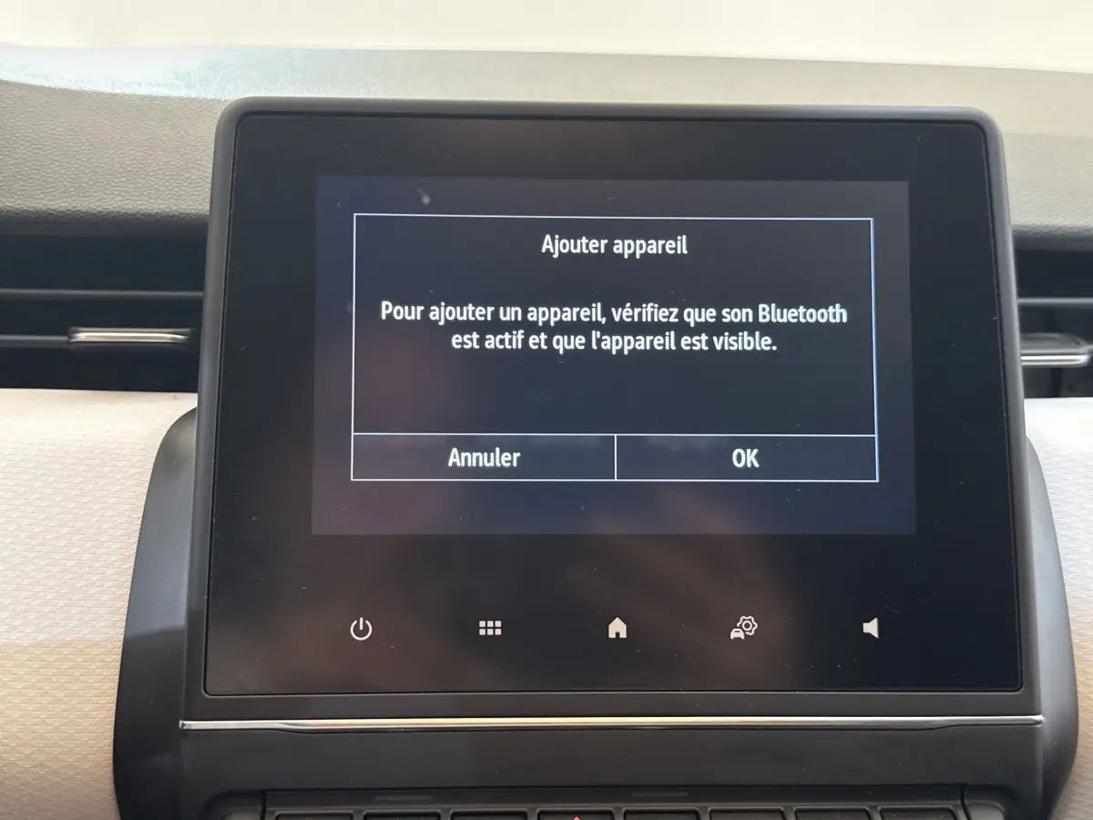 Écran tactile central du tableau de bord de la Renault Clio blanc, affichant un message Bluetooth.