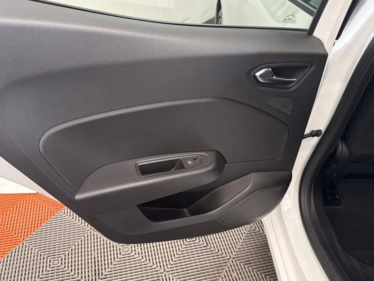 Vue intérieure de la porte arrière droite noire d’une Renault Clio blanche Evolution TCe 100 GPL 2023.