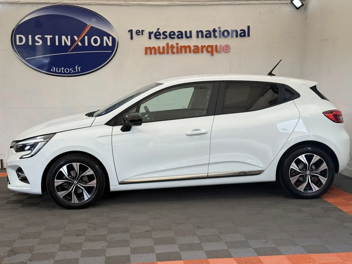 Profil droit d'une Renault Clio Evolution TCe 100 GPL blanche, avec jantes alliage bicolores et rétroviseurs noirs.