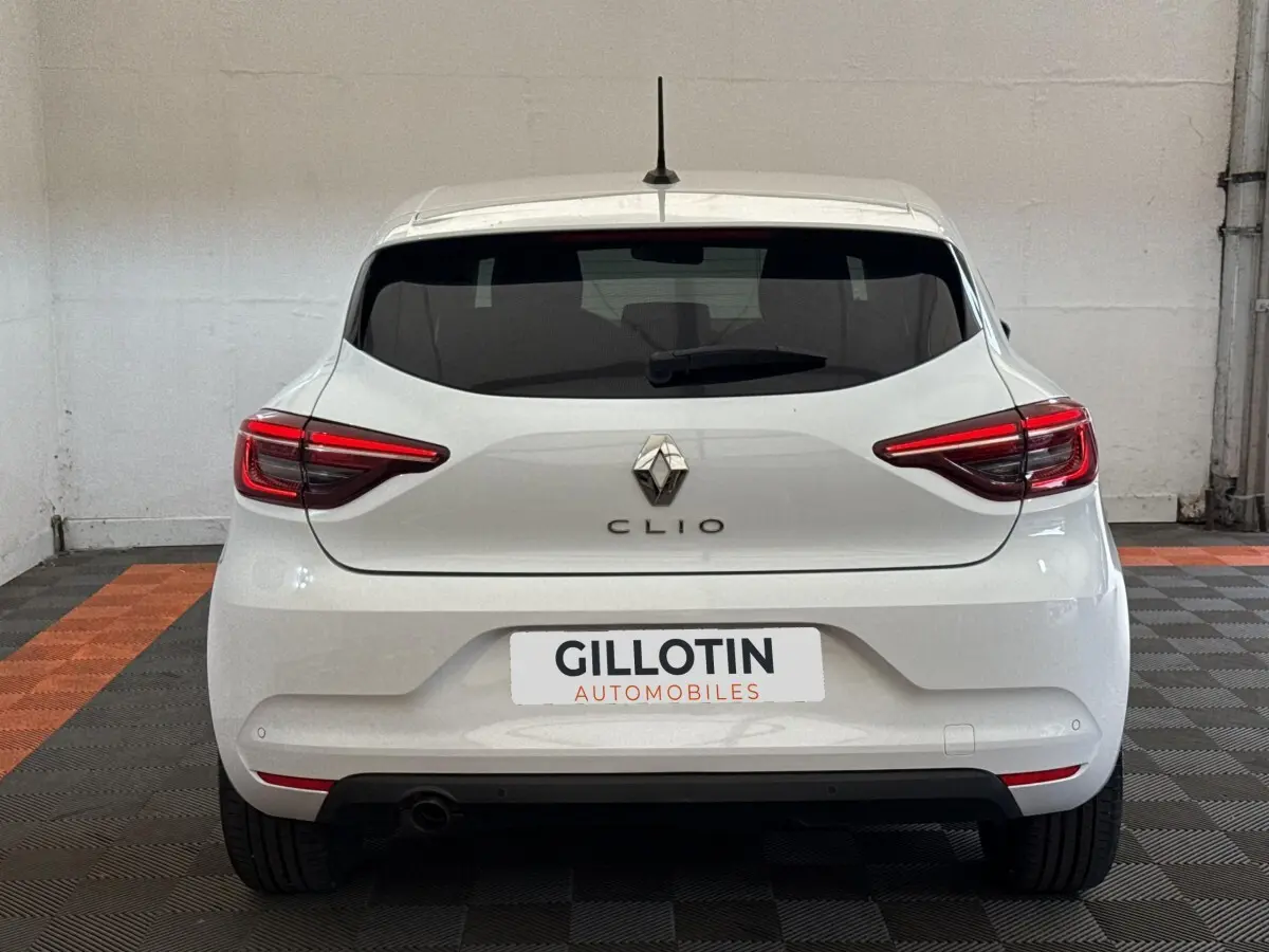 Vue arrière d'une Renault Clio blanche 2023 avec feux LED et logo Renault bien visibles.