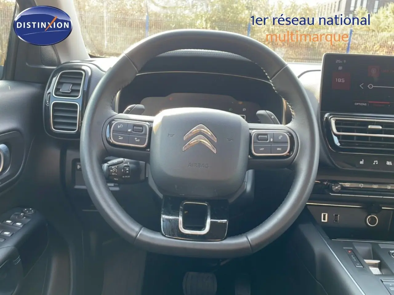 Vue intérieure centrée sur le volant du Citroën C5 Aircross 2025, avec tableau de bord et écran tactile visibles.