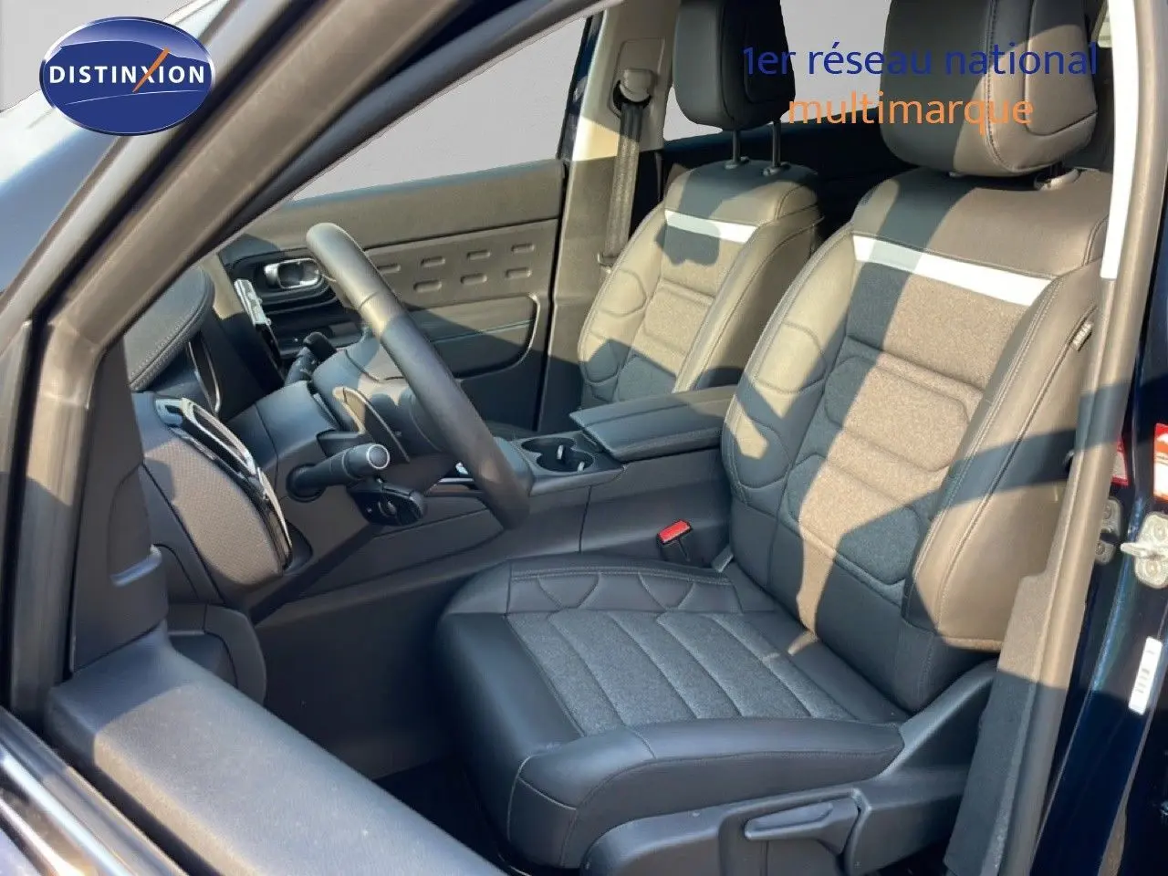 Vue intérieure côté conducteur du Citroën C5 Aircross bleu Eclipse Metal, sièges tissu et cuir noir avec surpiqûres grises.
